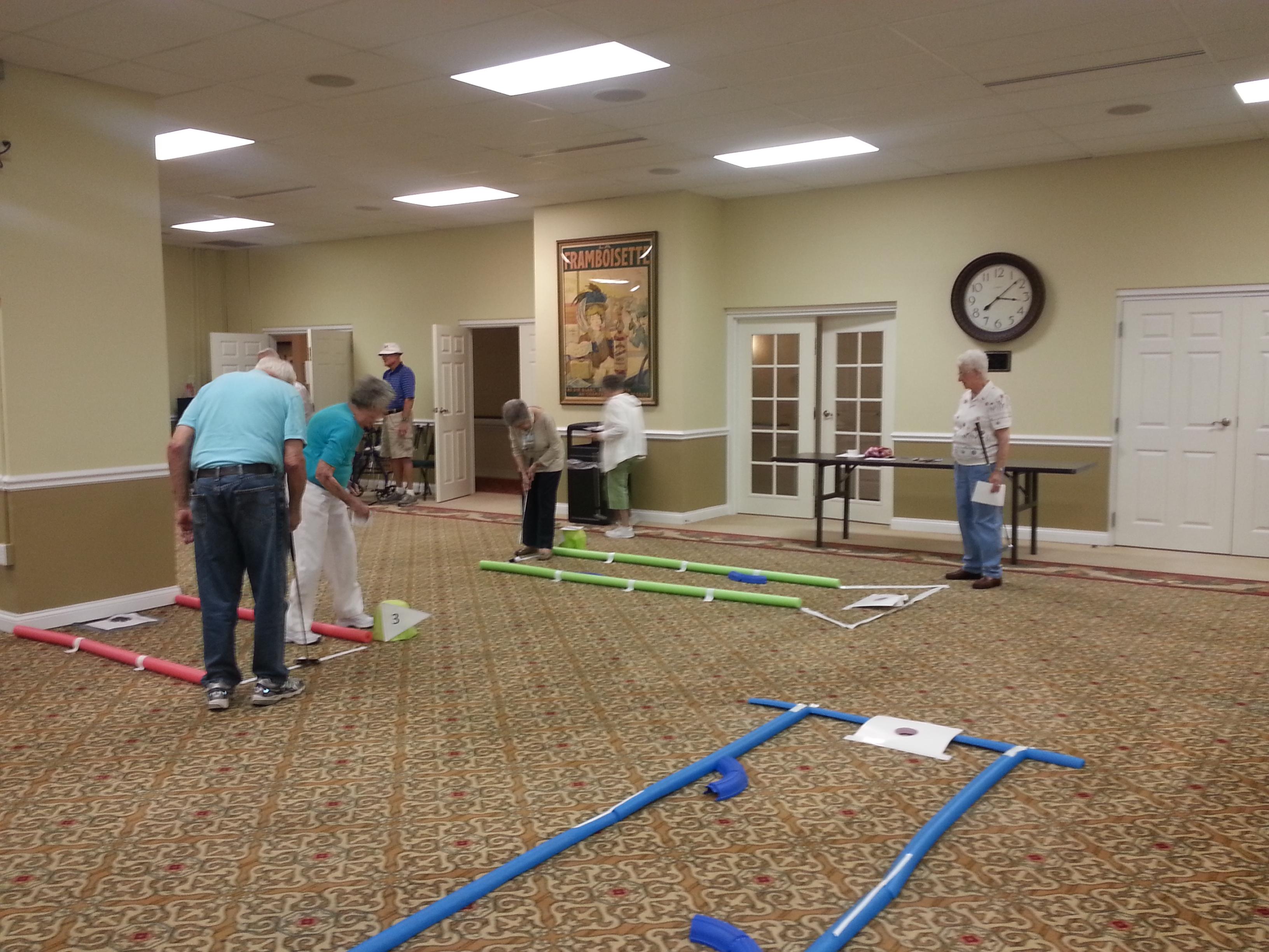 residents on indoor putting course